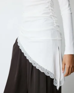 Top asymétrique manches longues bas en dentelle ivoire Bina